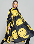 Rainkiss All Smiley Regenponcho mit gelben Smileys auf schwarzem Mantel Model mit Sonnenbrille
